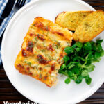 Overhead vegetarian cauliflower and ricotta stuffed and baked cannelloni served on a plate, featuring a title overlay.