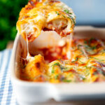 Close-up vegetarian cauliflower and ricotta cheese cannelloni being served from a baking dish.