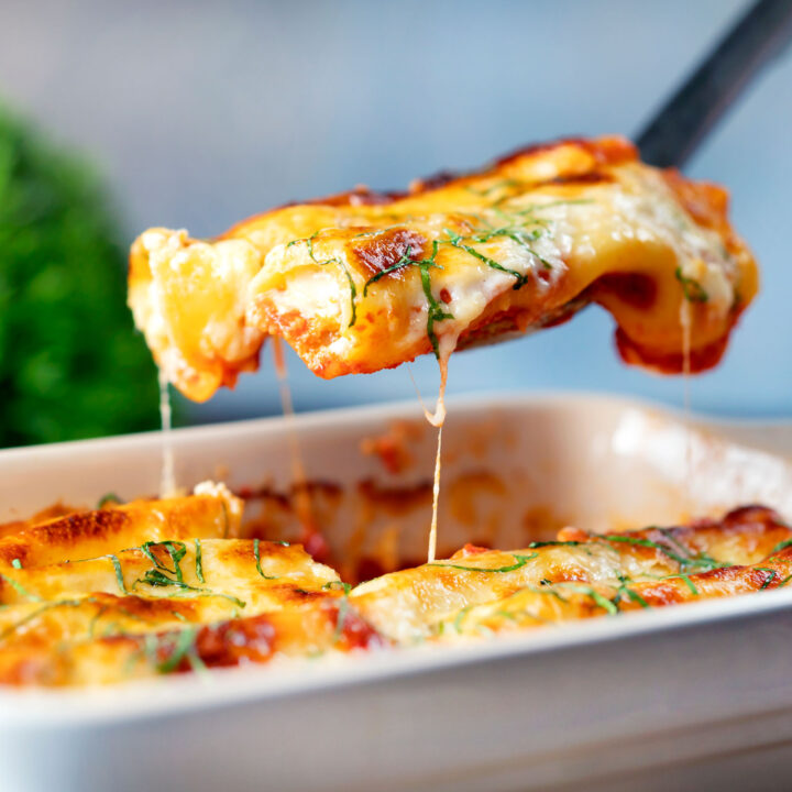 Vegetarian cauliflower and ricotta cheese cannelloni being served from a baking dish.