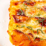 Close-up vegetarian cauliflower and ricotta stuffed and baked cannelloni served on a plate.