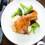 Overhead oven baked brown sugar pork chops served with celeriac mash and broccoli.