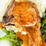 Overhead close-up oven baked brown sugar pork chops served with celeriac mash and broccoli.