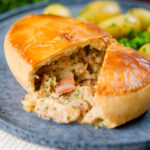 Homemade creamy chicken and bacon pie with peas and buttered potatoes.