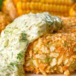 Close-up baked crab cakes with fennel and chives served with homemade tartar sauce.