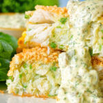Close-up homemade crab cakes cut open to show texture served with tartar sauce.