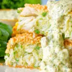 Close-up homemade crab cakes cut open to show texture served with tartar sauce.