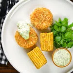 Overhead baked crab cakes with fennel and chives served with homemade tartar sauce.