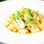 Creamy cheesy smoked haddock pasta made with penne garnished with snipped chives.