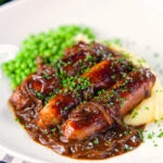 Devilled sausages in a spicy onion gravy with mashed potato and peas.