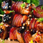 Close-up marmalade glazed duck kebabs served with a fennel and orange salad.