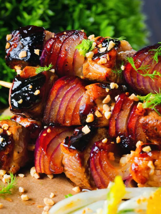 Close-up marmalade glazed duck kebabs served with a fennel and orange salad.