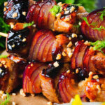 Close-up marmalade glazed duck kebabs served with a fennel and orange salad.