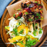 Overhead marmalade glazed duck kebabs served with a fennel and orange salad.