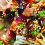 Overhead marmalade glazed duck skewers served with a fennel and orange salad.