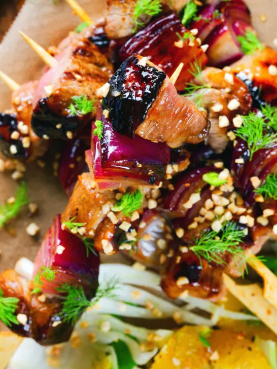 Overhead marmalade glazed duck skewers served with a fennel and orange salad.