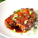 Filipino inspired adobo pork chops served with rice and spring onions.