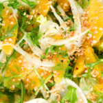 Overhead close-up fennel and orange salad with roasted almonds and rocket.