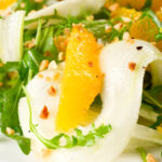 Close-up fennel and orange side salad with roasted almonds and rocket.