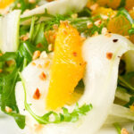 Close-up fennel and orange side salad with roasted almonds and rocket.