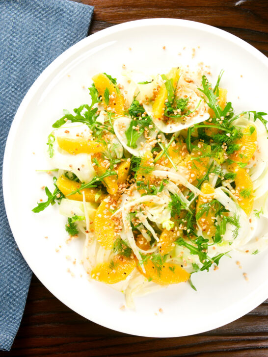 Overhead fennel and orange side salad with roasted almonds and rocket.