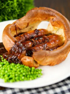 Individual toad in the hole for served with a rich onion gravy and garden peas.