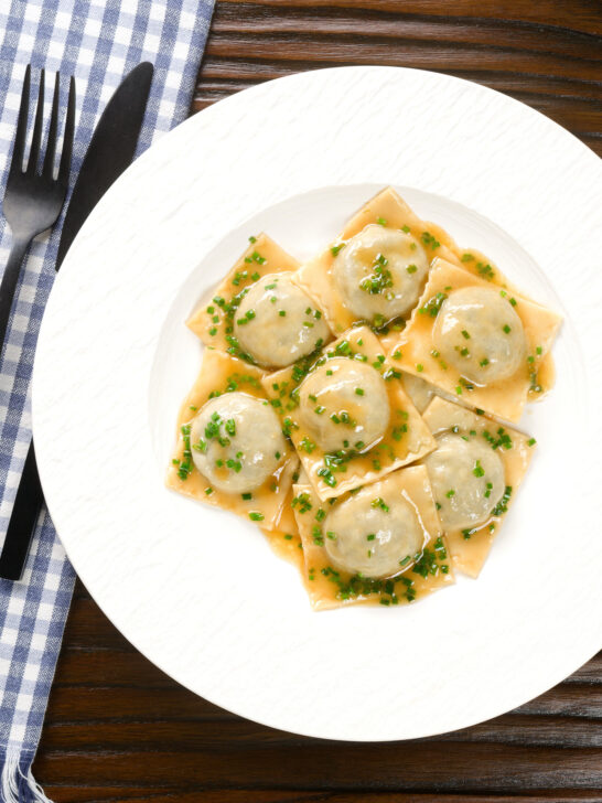 Overhead homemade mushroom filled ravioli in a marsala wine, butter and chive sauce.