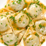 Overhead close-up mushroom filled ravioli in a marsala wine, butter and chive sauce.