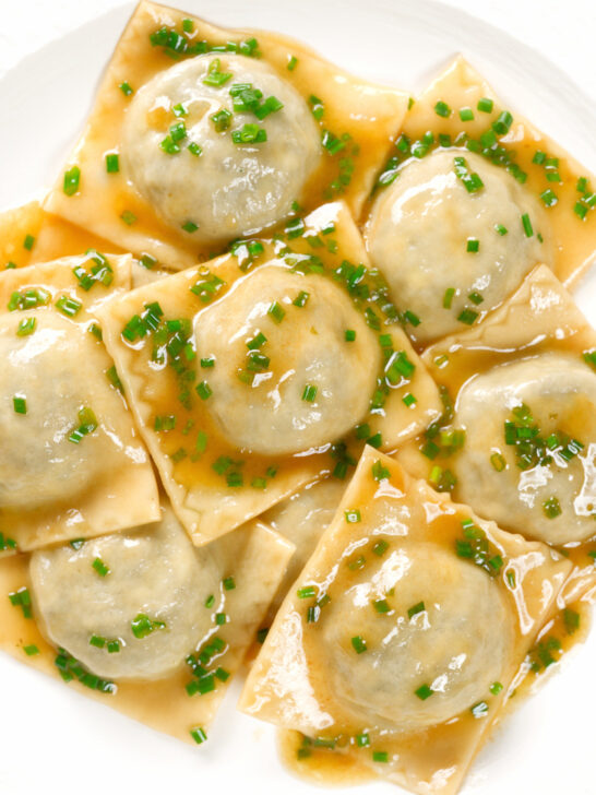 Overhead close-up mushroom filled ravioli in a marsala wine, butter and chive sauce.