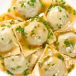Overhead close-up mushroom filled ravioli in a marsala wine, butter and chive sauce.