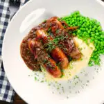 Overhead devilled sausages in a spicy onion gravy with mashed potato and peas.