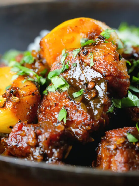 Close-up pork belly curry with tamarind, black pepper and whole garlic cloves.