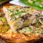 Potato and onion frittata with smoked mackerel and capers cut to show the filling.