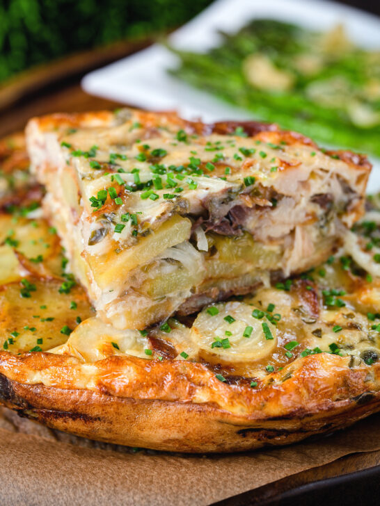 Potato and onion frittata with smoked mackerel and capers cut to show the filling.