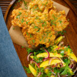 Overhead prawn or shrimp and sweetcorn fritters served with a mango and red onion salad.