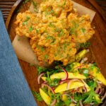 Overhead prawn or shrimp and sweetcorn fritters served with a mango and red onion salad.