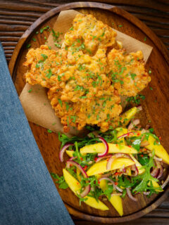 Overhead prawn or shrimp and sweetcorn fritters served with a mango and red onion salad.