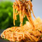 Spaghetti alla puttanesca being eaten with a fork.