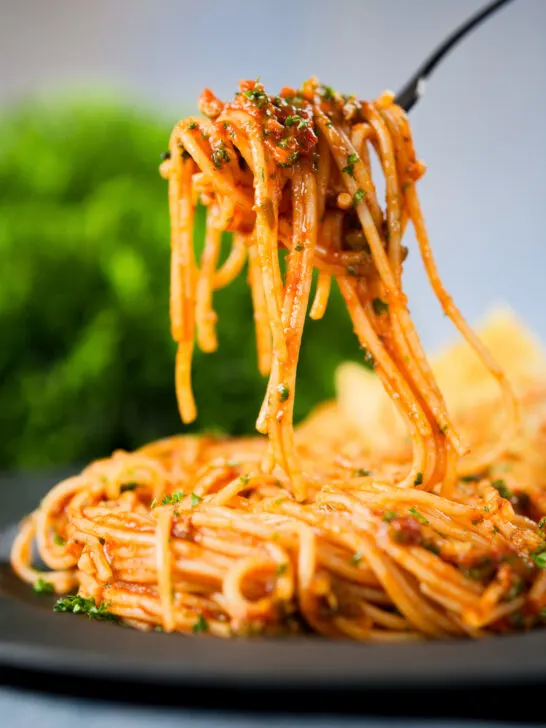 Spaghetti alla puttanesca being eaten with a fork.