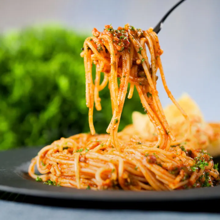 Quick and easy spaghetti alla puttanesca serve with garlic bread.
