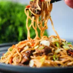 Beef yakisoba noodle stir fry being eaten with chopsticks.