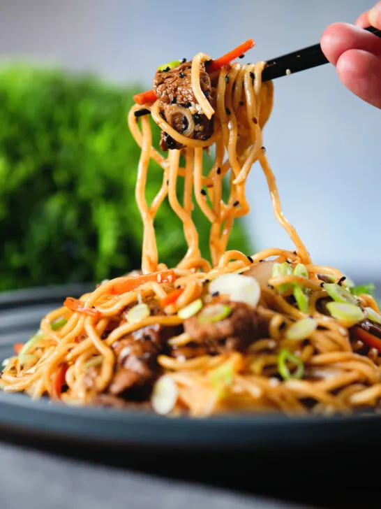 Beef yakisoba noodle stir fry being eaten with chopsticks.