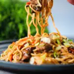 Beef yakisoba noodle stir fry being eaten with chopsticks.