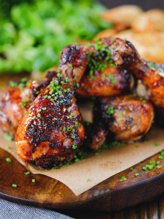 Baked sticky chicken drumsticks with a cherry balsamic glaze served with wedges.