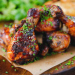 Baked sticky chicken drumsticks with a cherry balsamic glaze served with wedges.