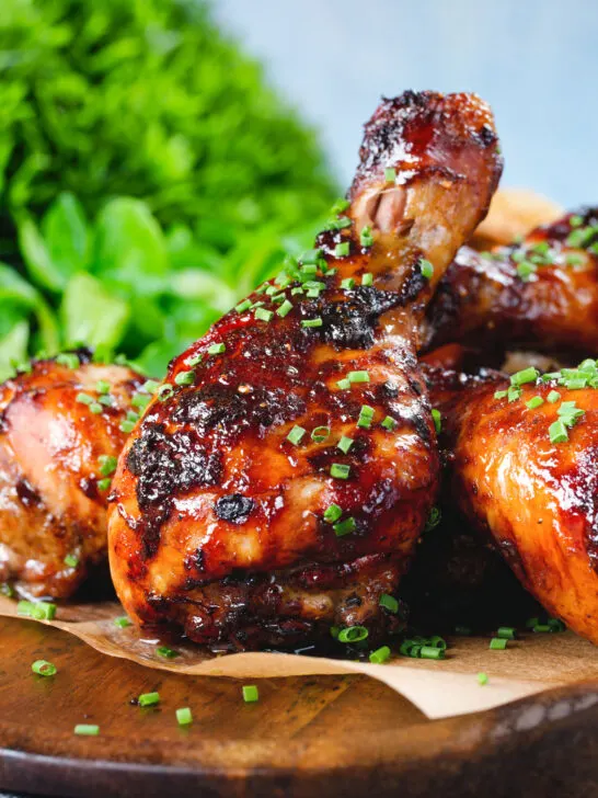 Close-up baked sticky chicken drumsticks with a cherry and balsamic vinegar glaze.