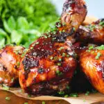 Close-up baked sticky chicken drumsticks with a cherry and balsamic vinegar glaze.