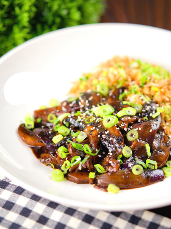 Teriyaki mushrooms stir fry served with egg fried rice and spring onions.