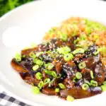 Teriyaki mushrooms stir fry served with egg fried rice and spring onions.