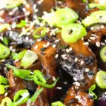 Close-up teriyaki mushrooms stir fry served with egg fried rice and spring onions.