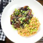 Overhead teriyaki mushrooms stir fry served with egg fried rice and spring onions.